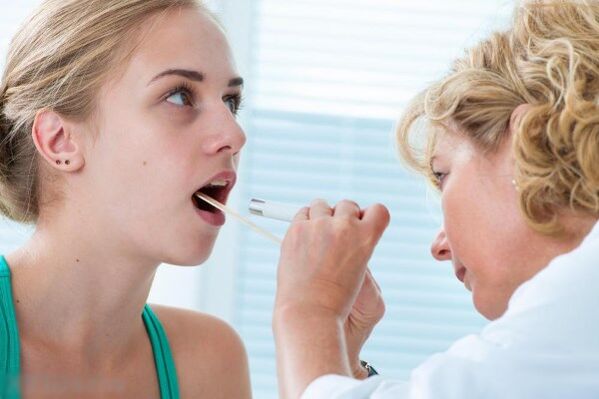 Lékař zkoumá dutinu ústní na přítomnost papilomů